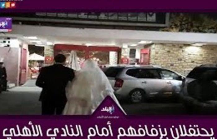 عروسان يحتفلان بزفافهما أمام النادي الأهلي.. فيديو